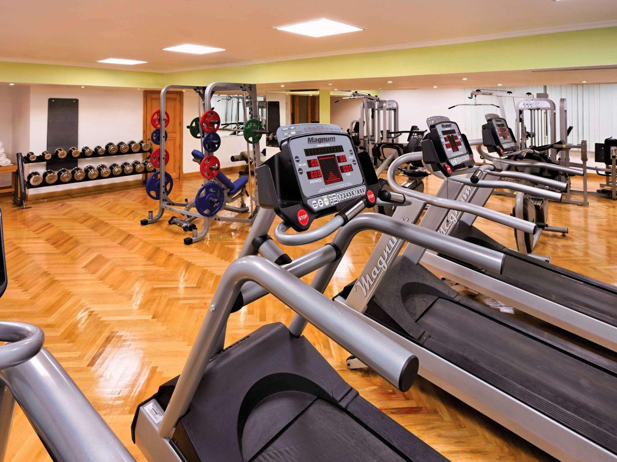 Movenpick Taba Resort & Spa Eksteriør billede The photo shows a modern gym interior featuring several exercise machines and equipment. In the foreground, there are multiple treadmills lined up, each equipped with electronic displays. In the background, there are various weightlifting equipment a
